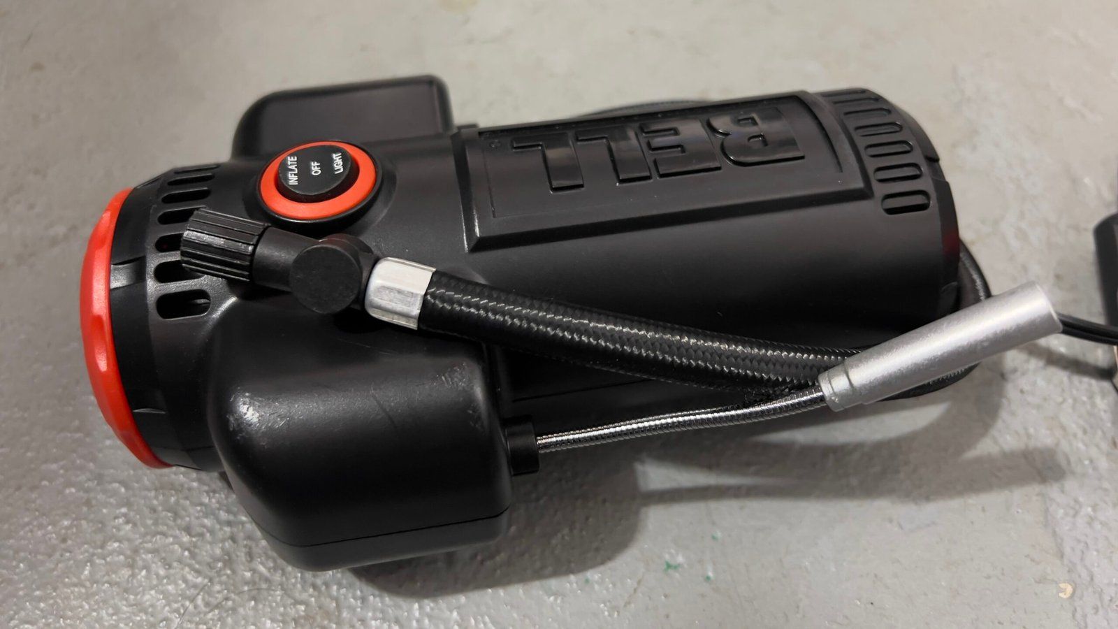 Portable tire inflator with an attached air hose