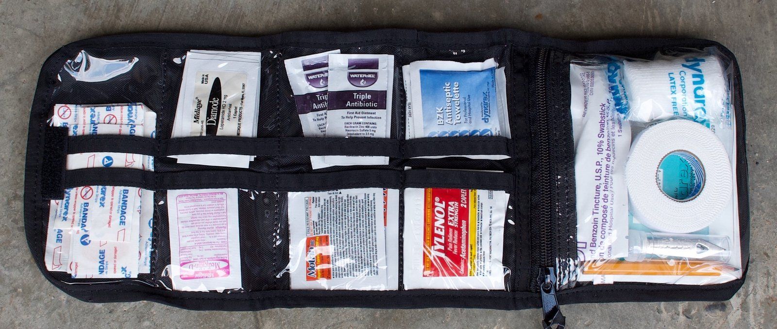 Open first aid kit with bandages, ointment and pain relievers